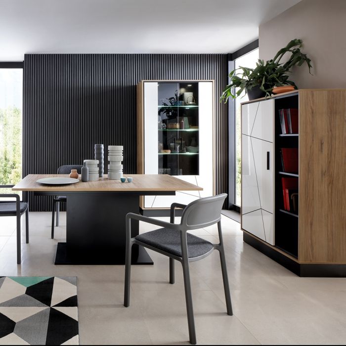 Modern dining area with a table, chairs, and a cabinet in a well-lit room.