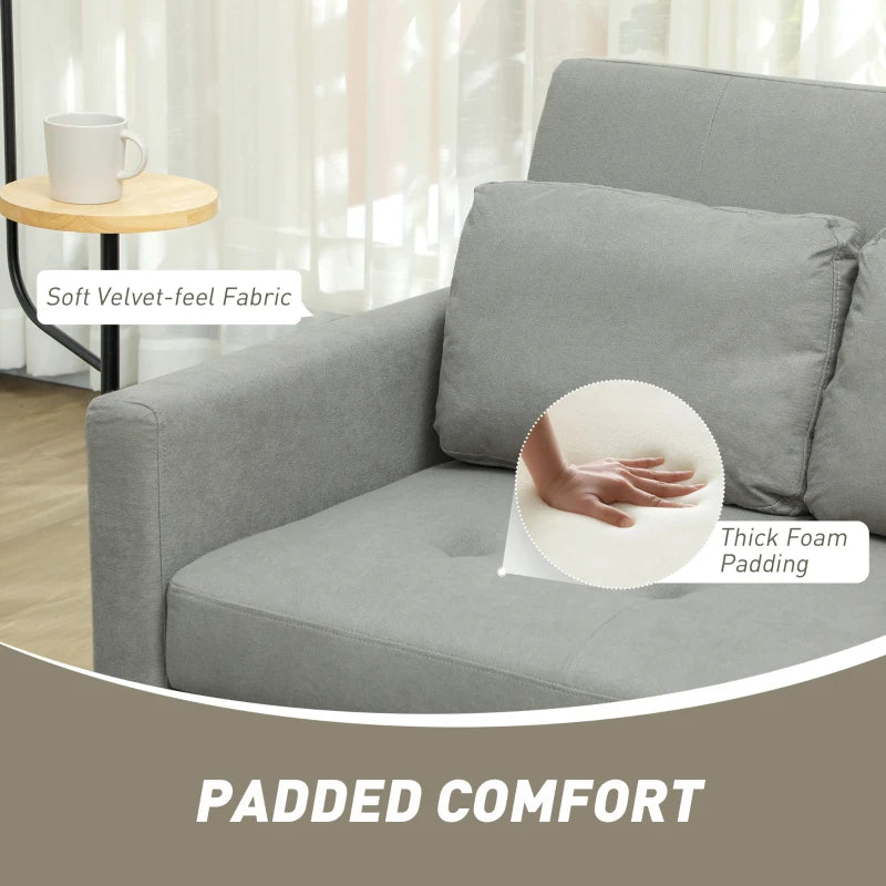 Gray sofa with text highlighting soft fabric and thick foam padding, in a living room setting.