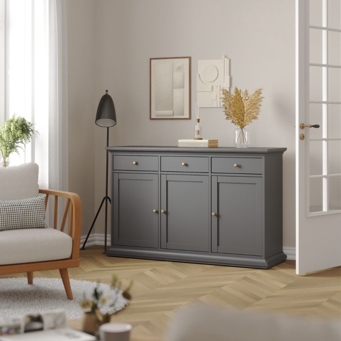 Gray sideboard in a living room with a lamp, sofa, and decor items.