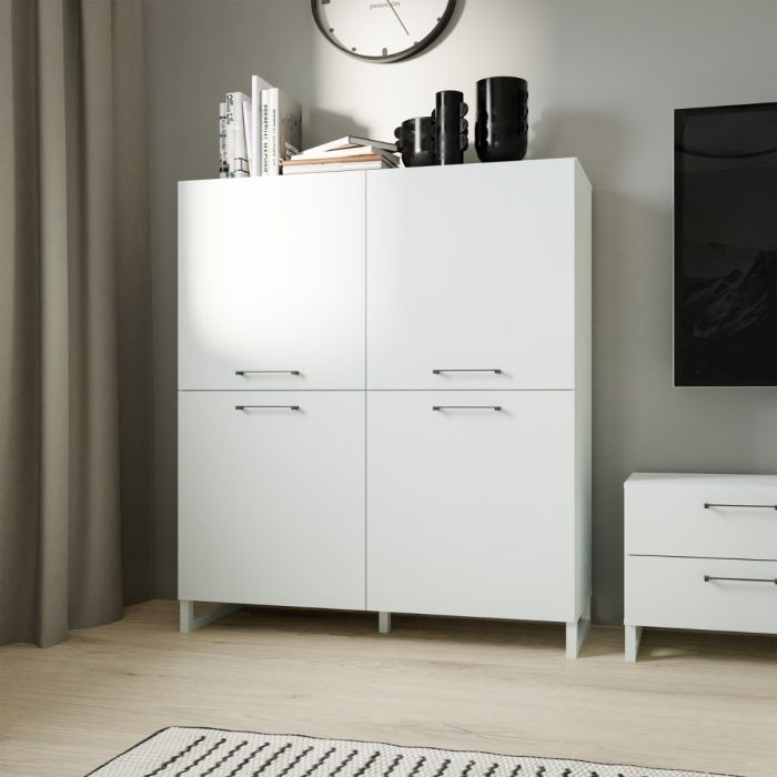 White dresser with four drawers in a room with a television and clock on the wall.