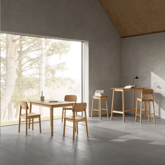 Modern dining area with wooden tables and chairs in a room with large windows.
