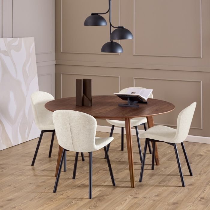 Dining area with a wooden table and white chairs in a room with beige walls and wooden flooring.