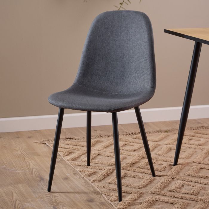 Gray chair with black legs on a wooden floor and beige wall background