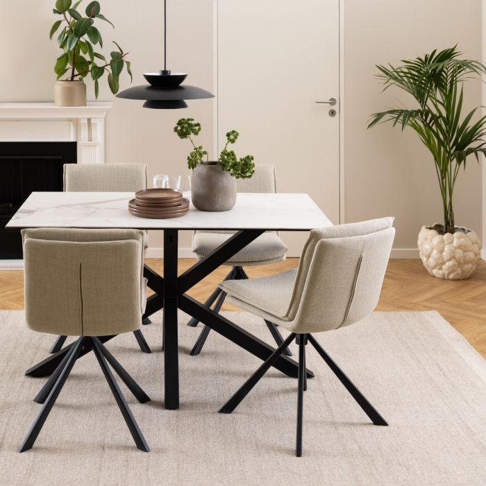 Dining room with a white table and gray chairs, featuring a fireplace and potted plants.