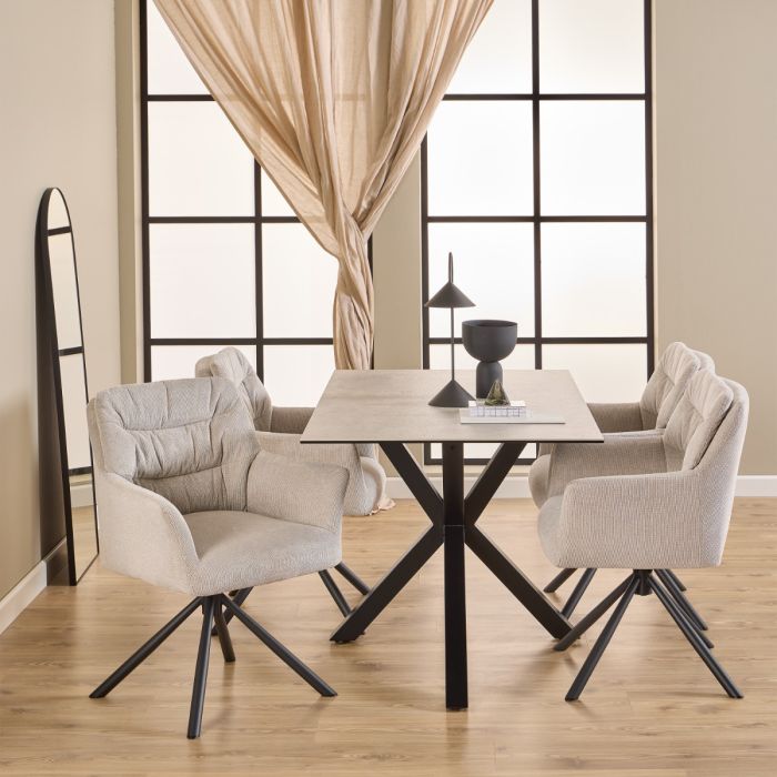 Dining room with a table and chairs in front of large windows with curtains.