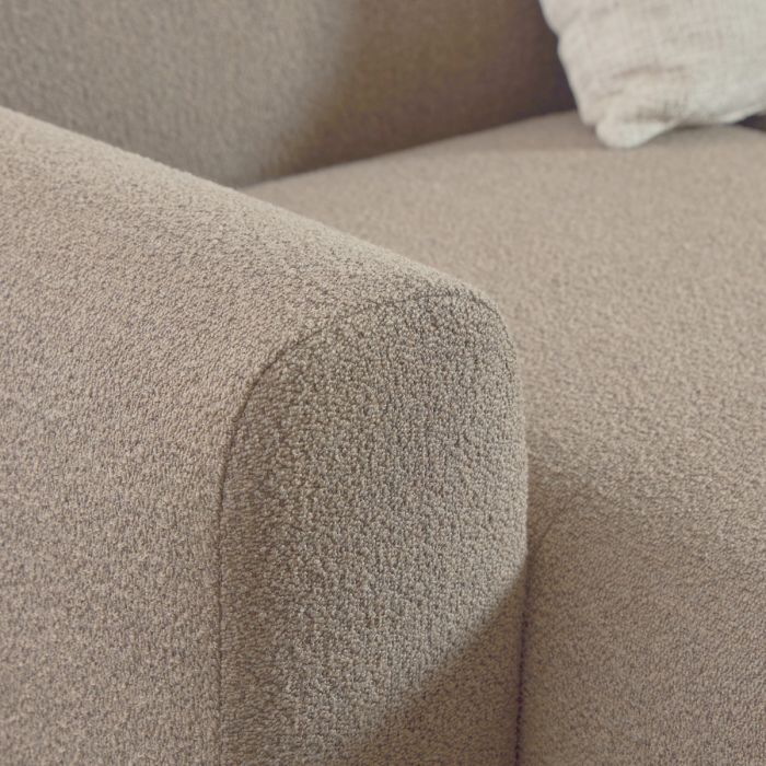 Close-up of a textured beige sofa armrest