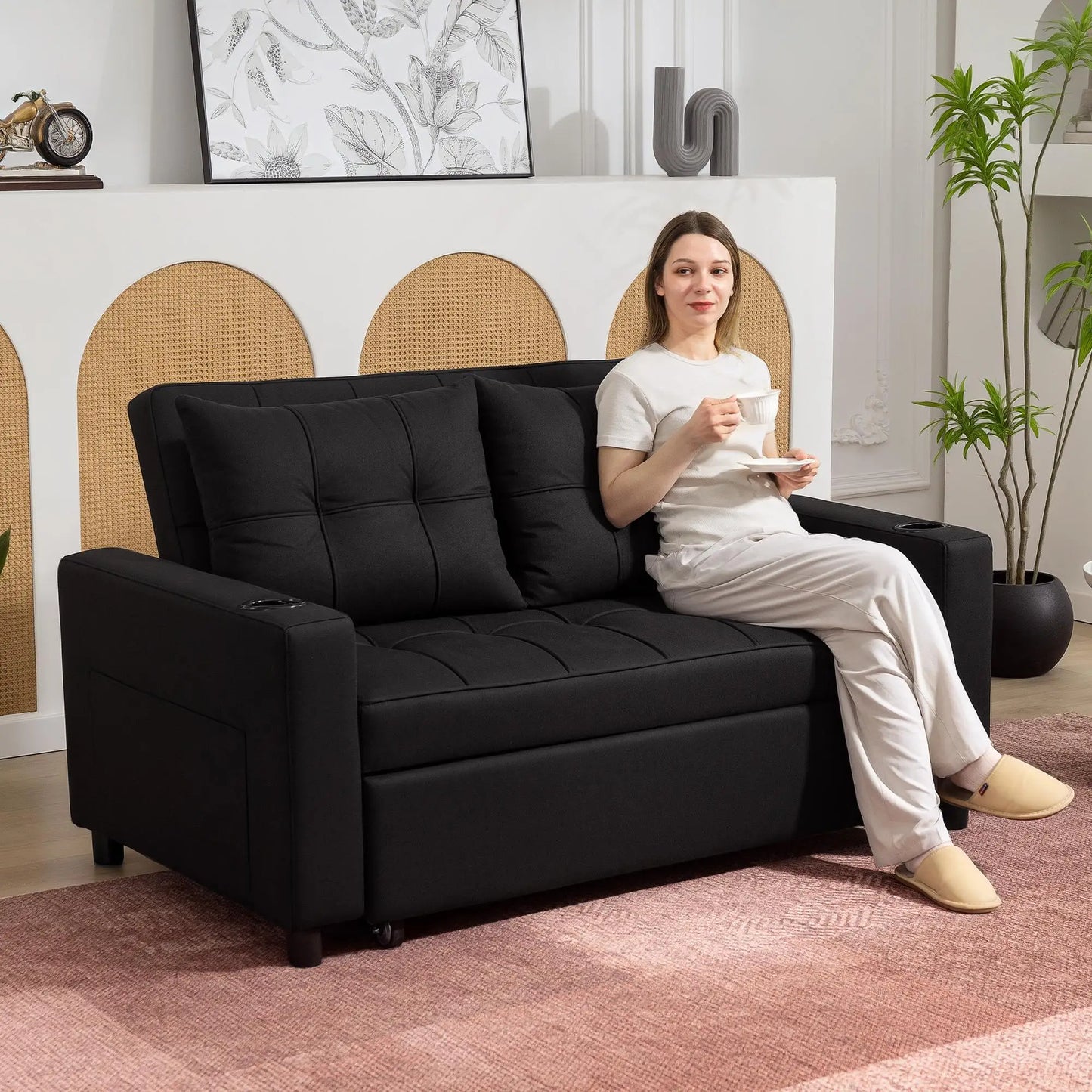 Woman sitting on a black sofa in a modern living room.