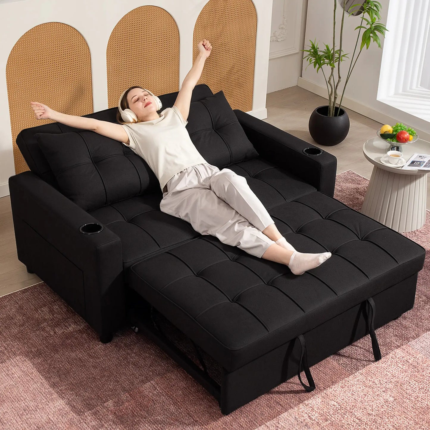 Person relaxing on a black sectional sofa in a living room setting.