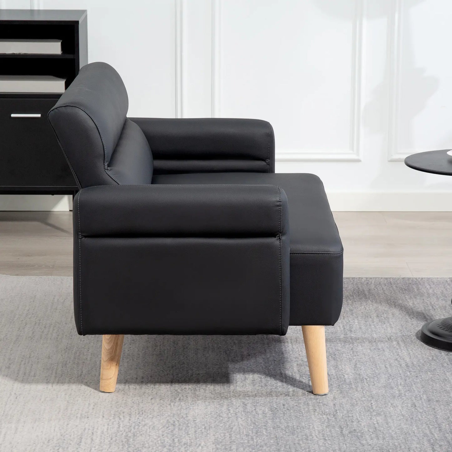 Black leather sofa with wooden legs in a room setting
