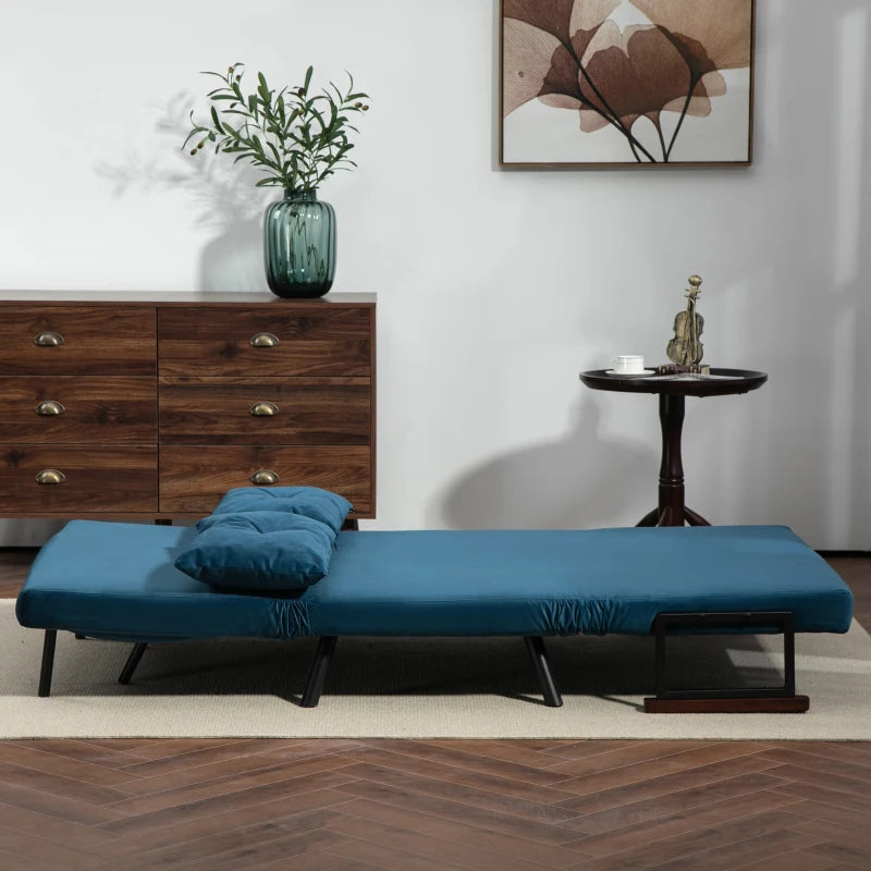 Blue futon couch in a room with wooden dresser and abstract painting