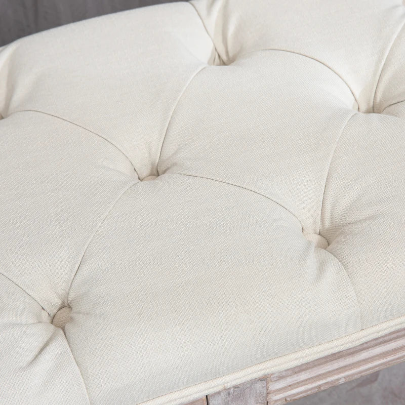 Close-up of a tufted white cushion on a piece of furniture.