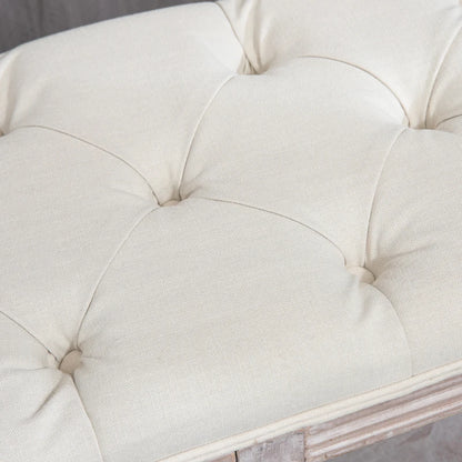 Close-up of a tufted white cushion on a piece of furniture.