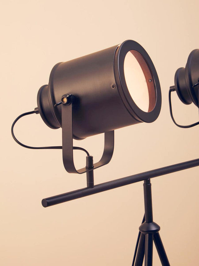 Vintage-style spotlight on a stand against a beige background