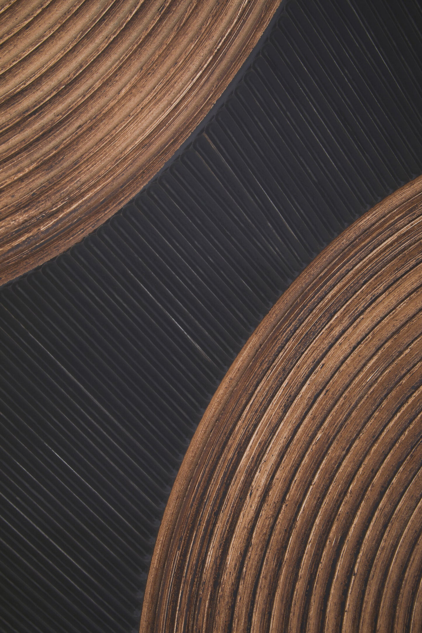 Close-up of two wooden coasters on a dark textured surface