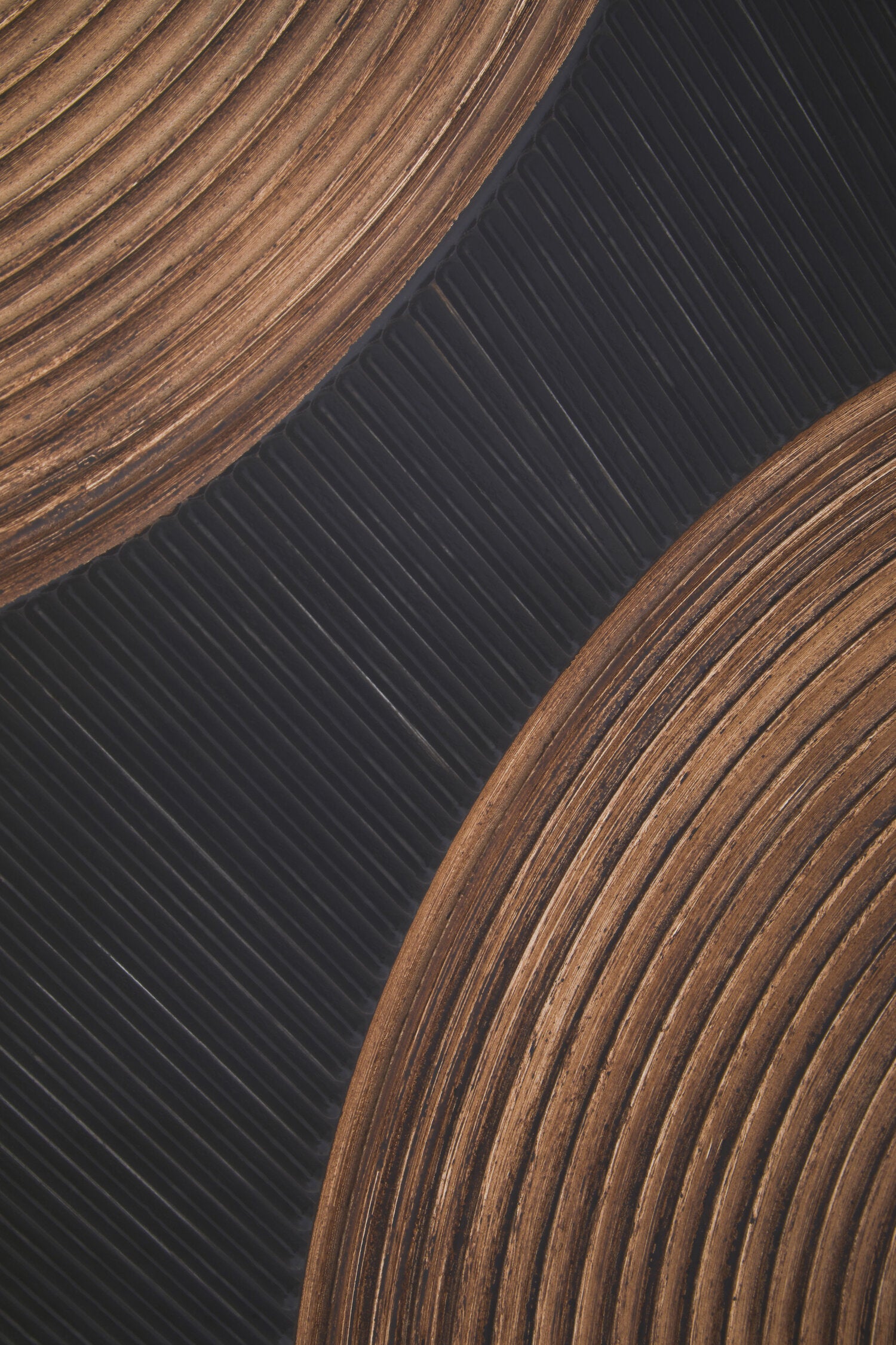 Close-up of two wooden coasters on a dark textured surface