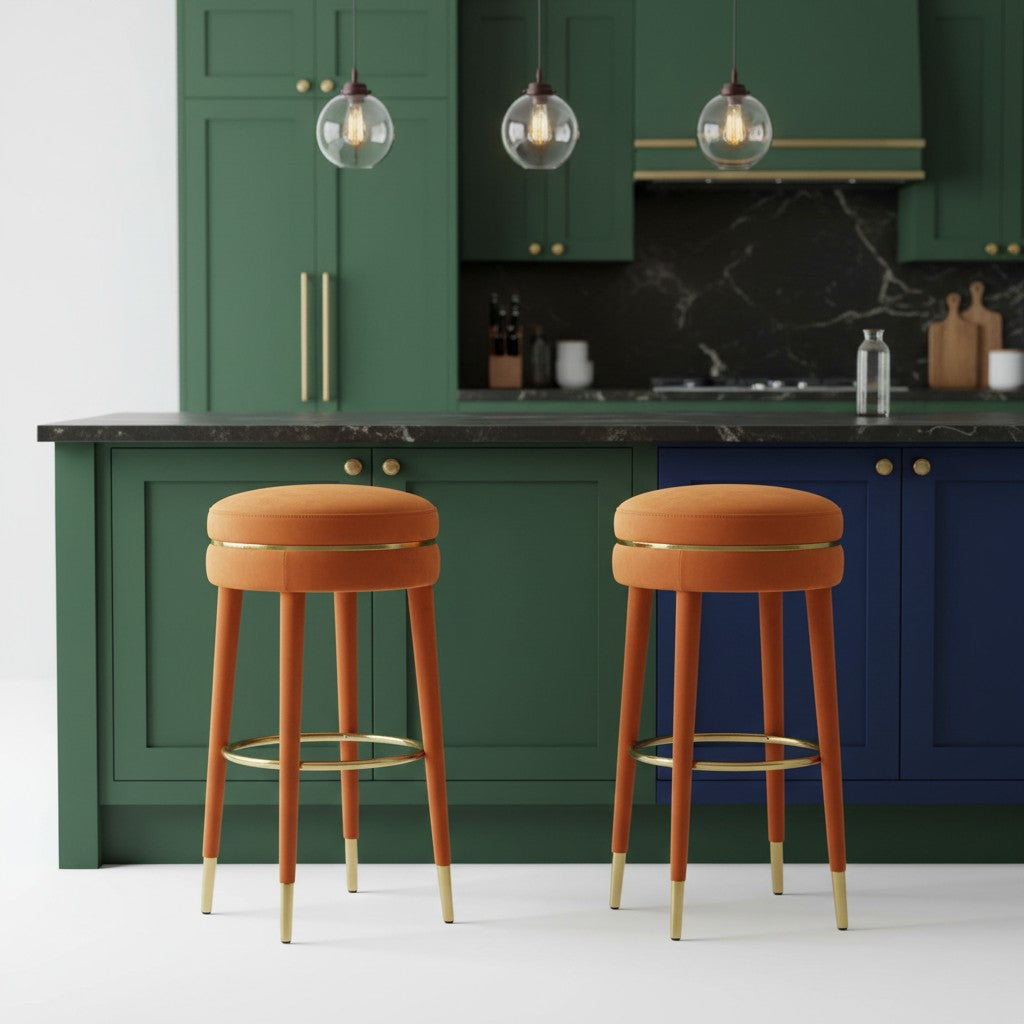 Two orange bar stools with gold legs in a kitchen setting.
