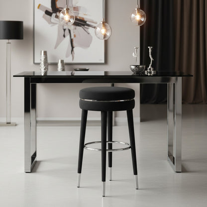 Modern black bar stool in front of a sleek black dining table with a neutral background.