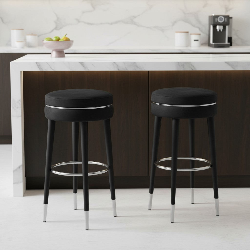 Two black bar stools with chrome legs in a kitchen setting.