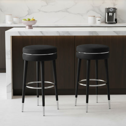 Two black bar stools with chrome legs in a kitchen setting.