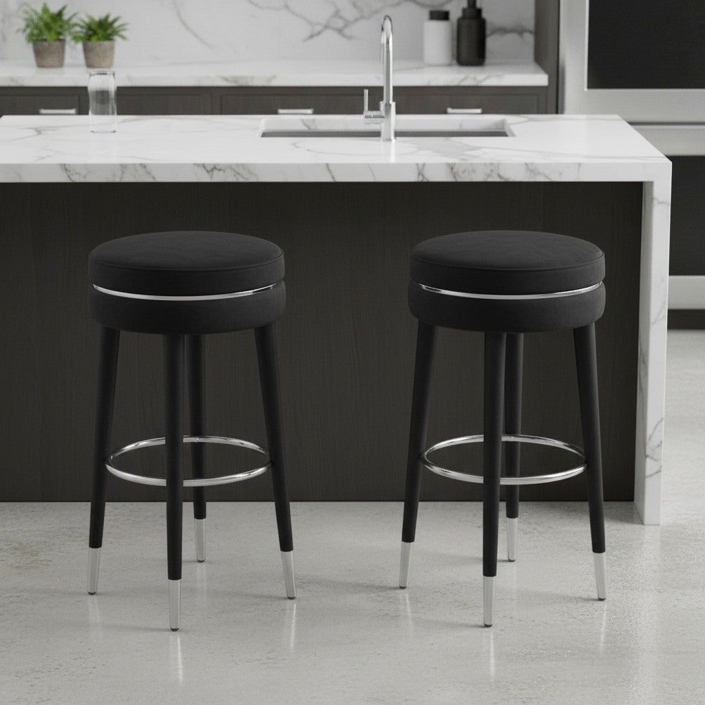 Two black bar stools with chrome legs in a modern kitchen setting.