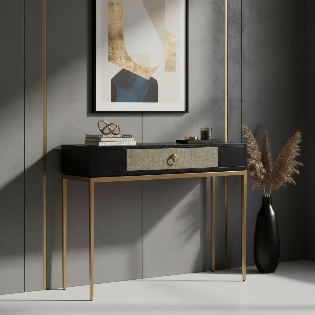 Modern console table with gold legs against a gray wall with abstract art.
