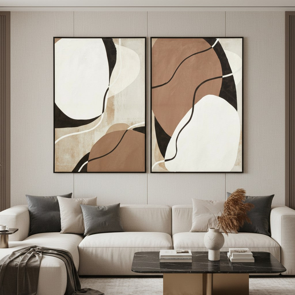 Two abstract paintings above a beige sofa in a living room setting.