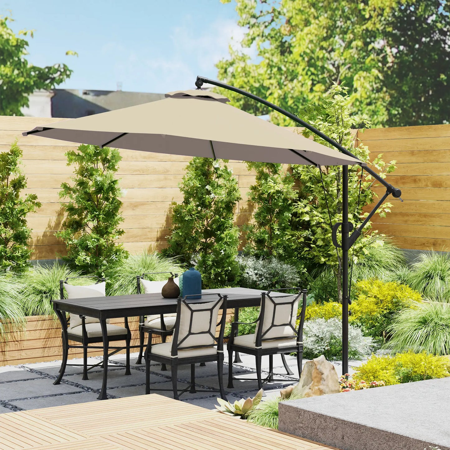 Outdoor patio set with table, chairs, and large umbrella in a garden setting.