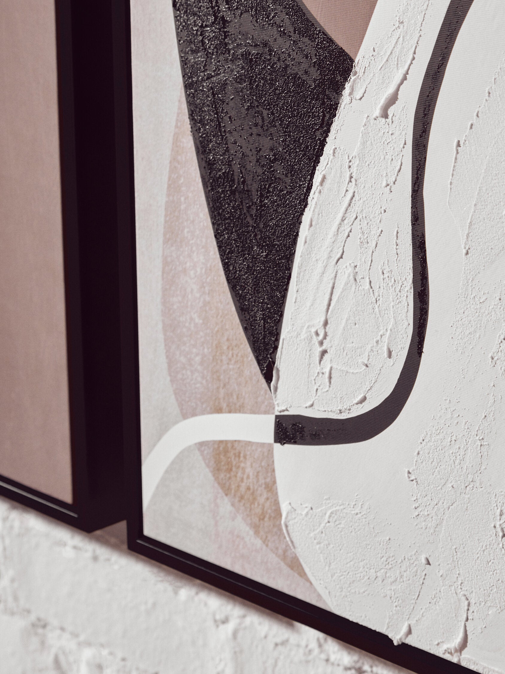 Close-up of a textured wall with abstract design and black frame.