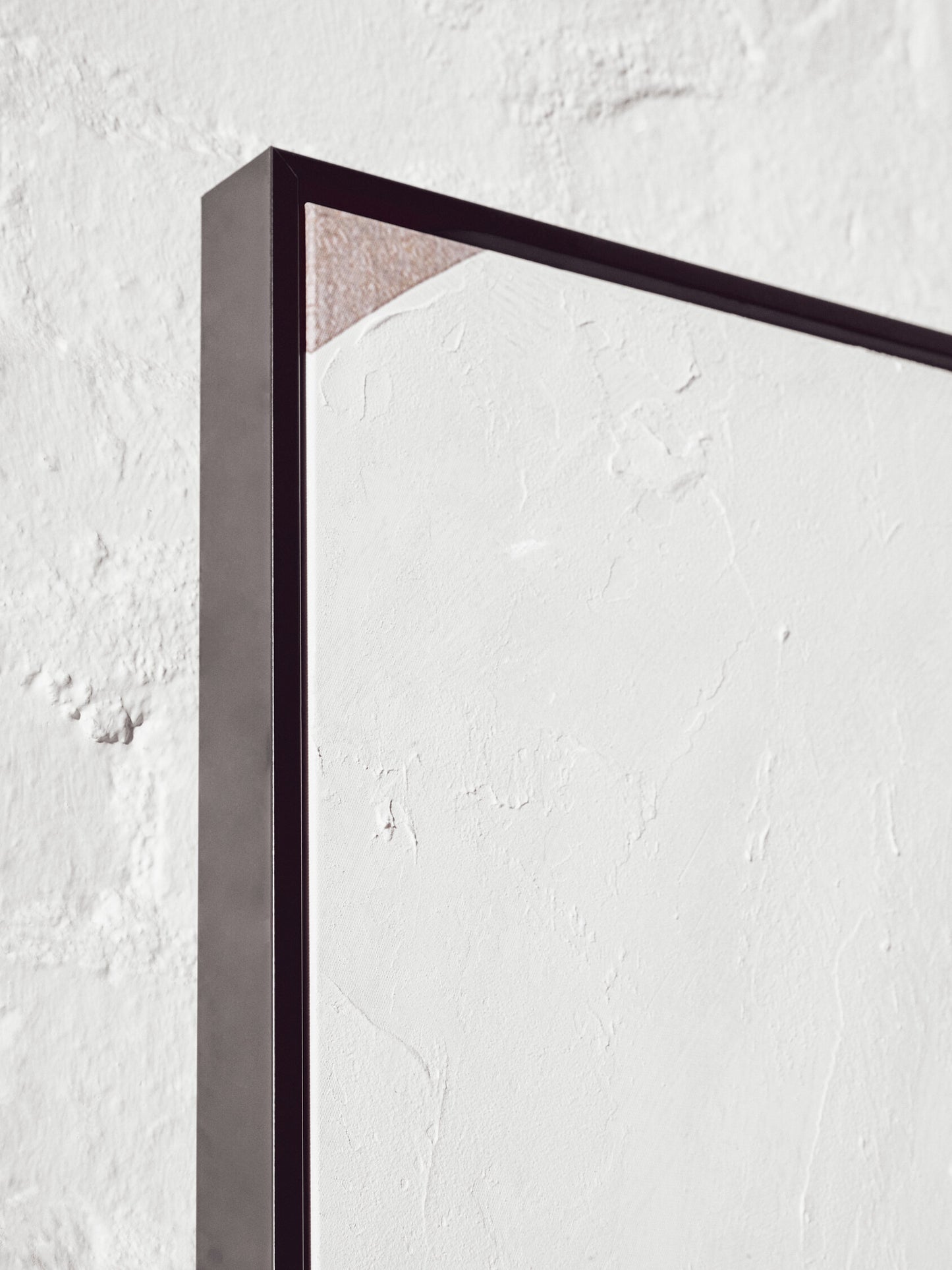Black rectangular frame on a textured white wall