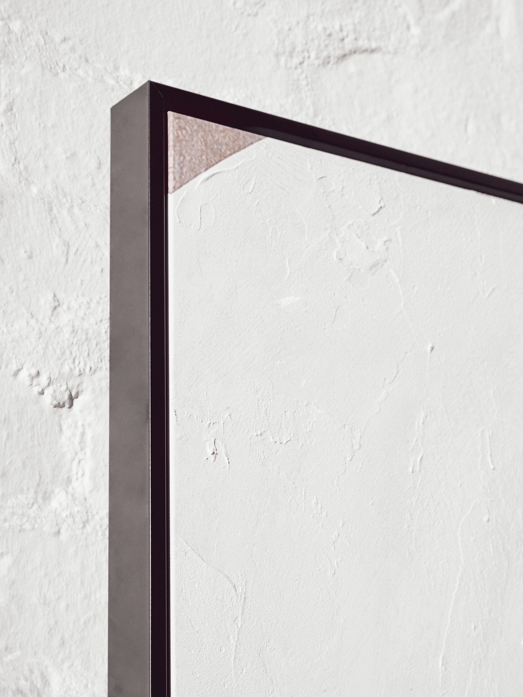 Black rectangular frame on a textured white wall