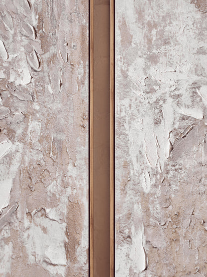 Close-up of a textured wall with a narrow metallic strip running vertically.