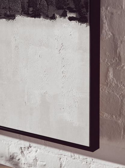 Framed abstract artwork on a textured wall