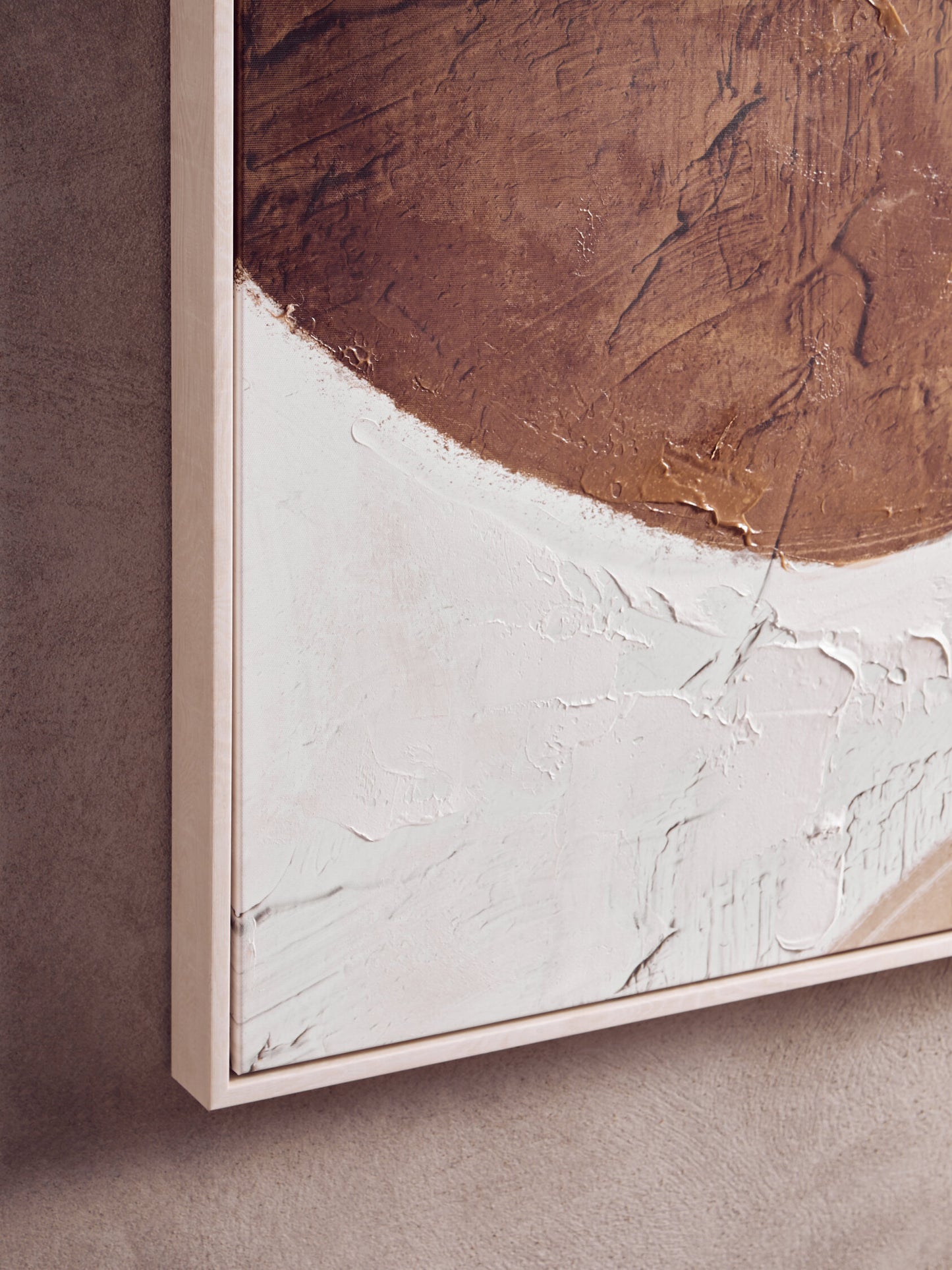 Abstract art piece with brown and white textures on a textured wall.