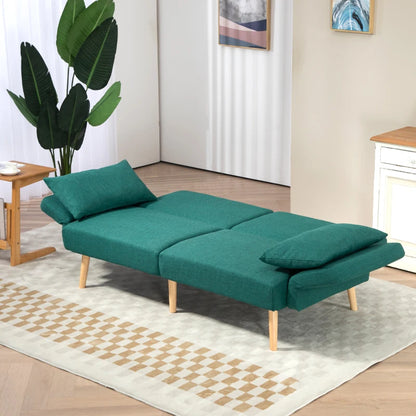 Green sofa bed in a room with a plant and side table.