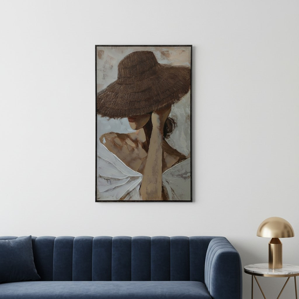 Framed artwork of a woman wearing a wide-brimmed hat above a blue sofa in a room.