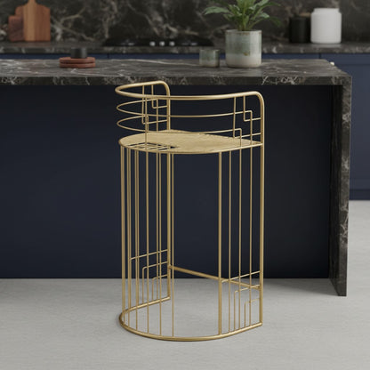 Gold metal side table with geometric design on a gray floor against a dark marble countertop.