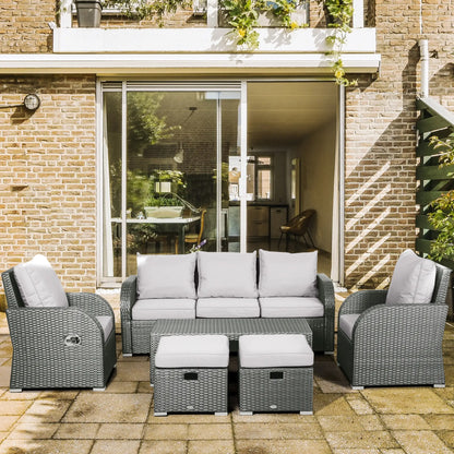 Outdoor patio furniture set with gray cushions in front of a house.