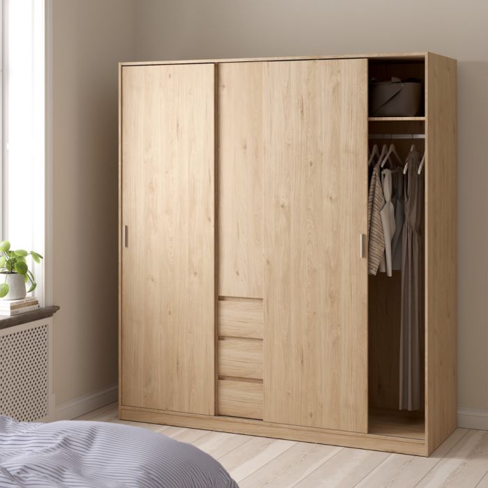Wooden wardrobe with clothes inside in a room with a window and radiator.