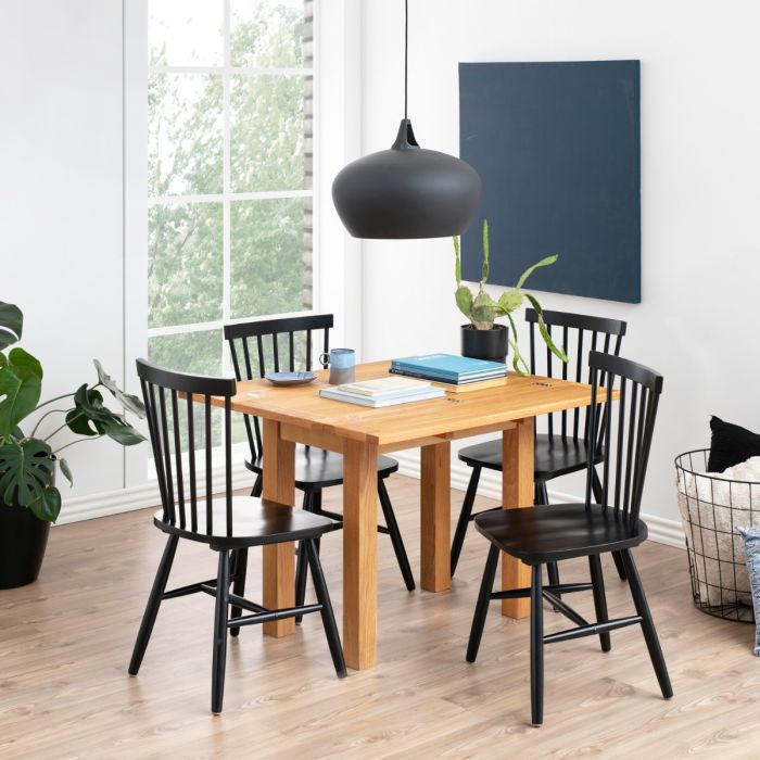 Dining room with wooden table and black chairs near a window