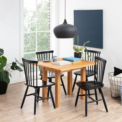 Dining room with wooden table and black chairs near a window