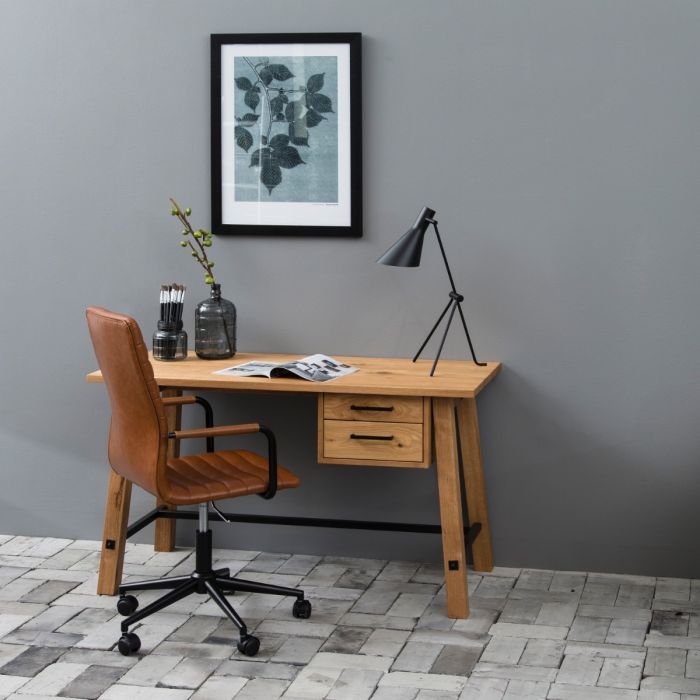 Wooden desk with a chair against a gray wall with a framed picture.