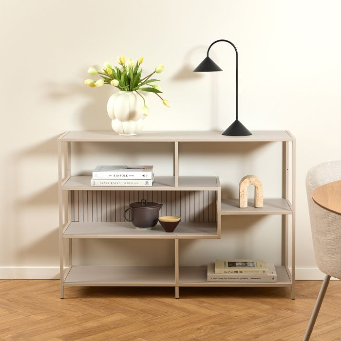 Beige bookshelf with decorative items against a beige wall