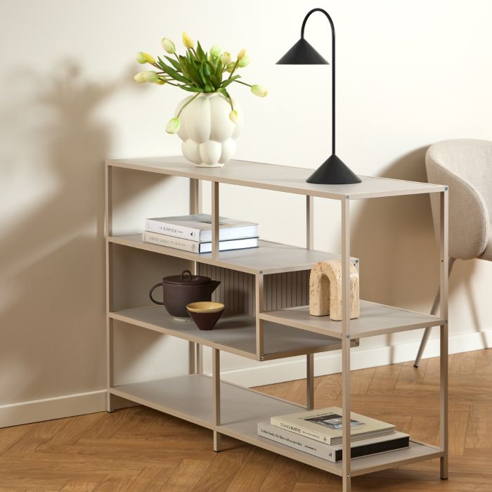 Modern bookshelf with decorative items against a neutral wall