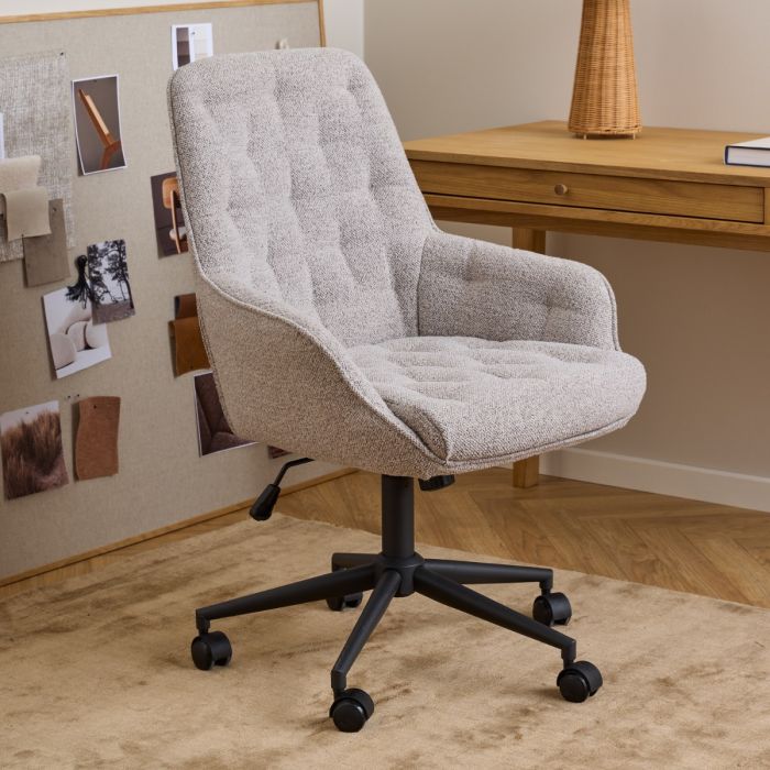 Beige office chair in a room with a wooden desk and decorative items on the wall.