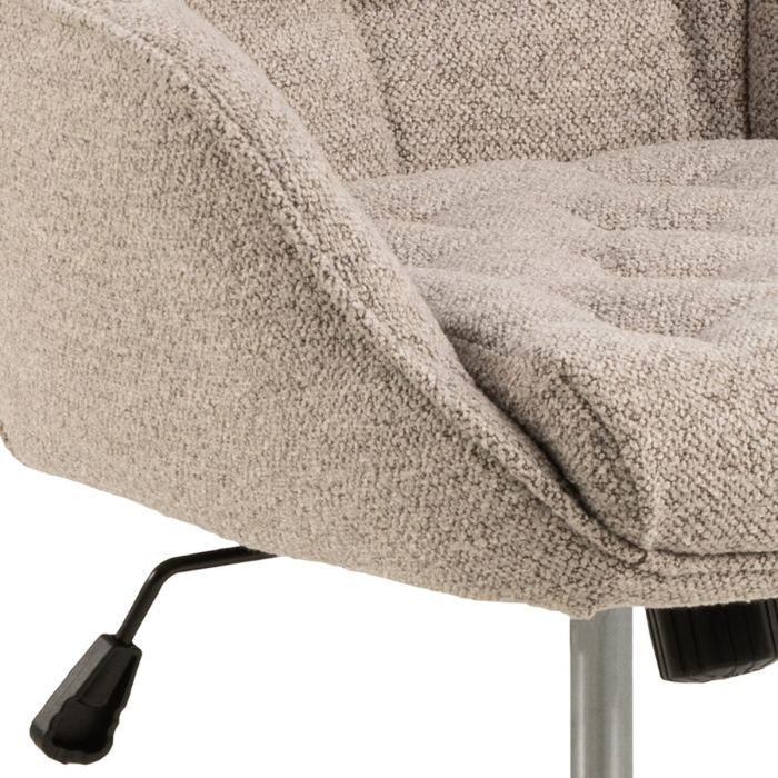 Close-up of a textured beige chair with a metal base on a white background