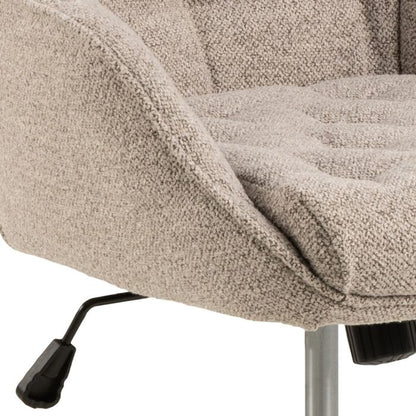 Close-up of a textured beige chair with a metal base on a white background