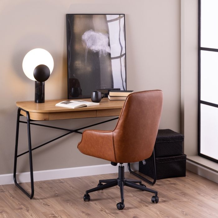 Modern home office with wooden desk, brown leather chair, and wall art.