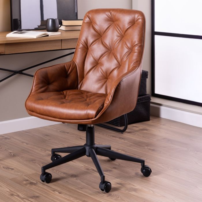 Brown leather office chair in a home office setting with a desk and window.