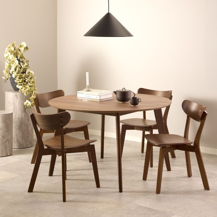 Dining room with wooden table and chairs, black pendant light, and decorative elements.