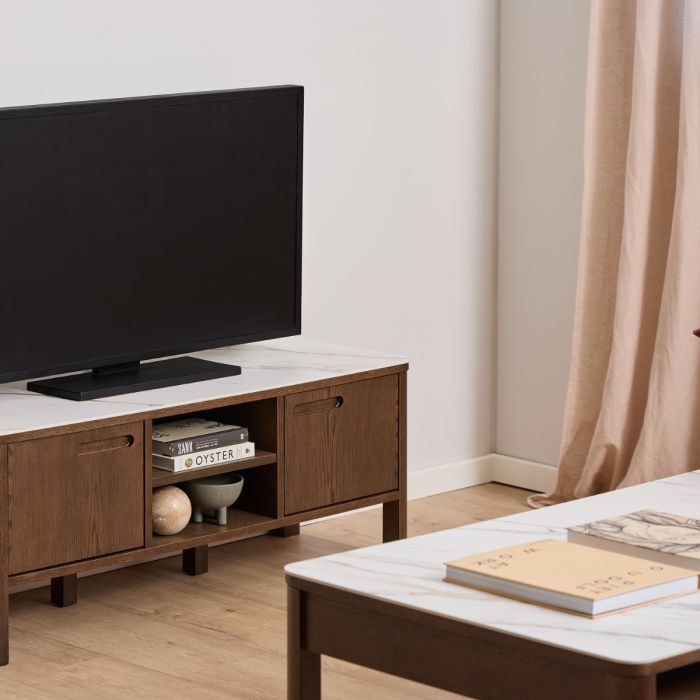 Wooden TV stand with a television and decorative items in a living room setting.